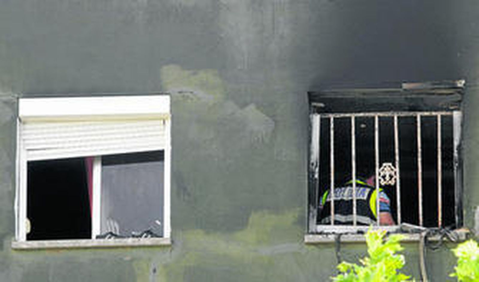 Un agente de la Policía Científica inspecciona el piso incendiado, ayer por la mañana.