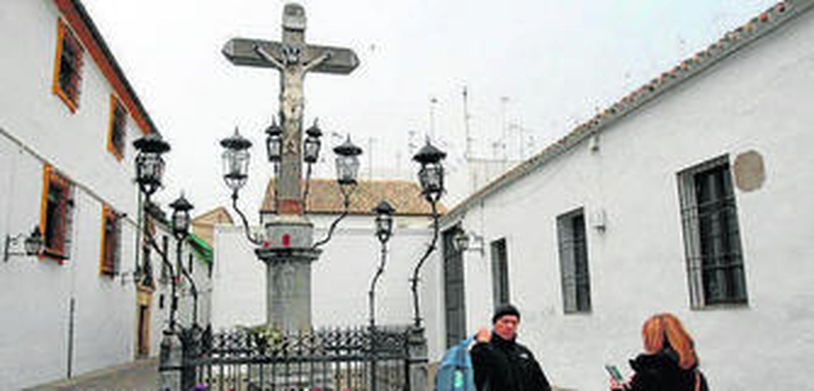 Dos turistas se fotografían ante el Cristo de los Faroles.