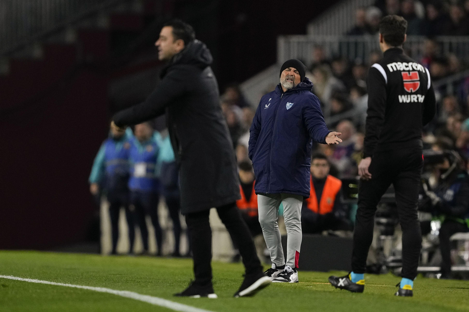 Sampaoli se queja al cuarto árbitro con Xavi desenfocado en primer plano.