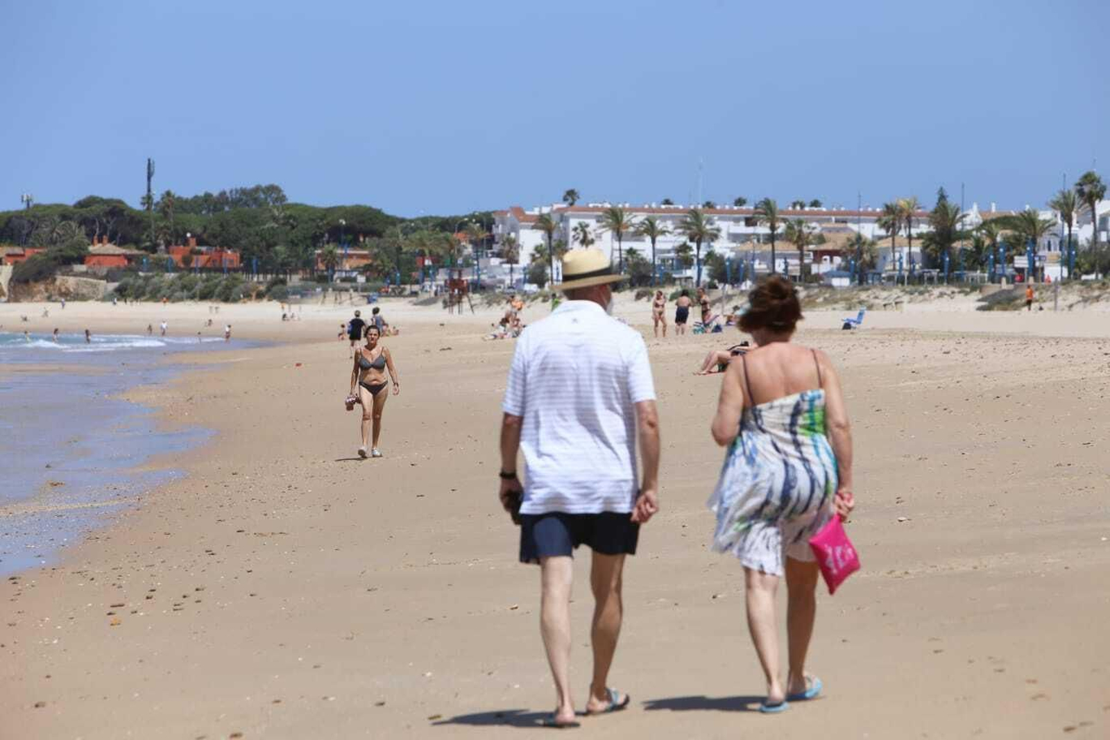 Bañistas paseando por la playa de La Barrosa en Chiclana