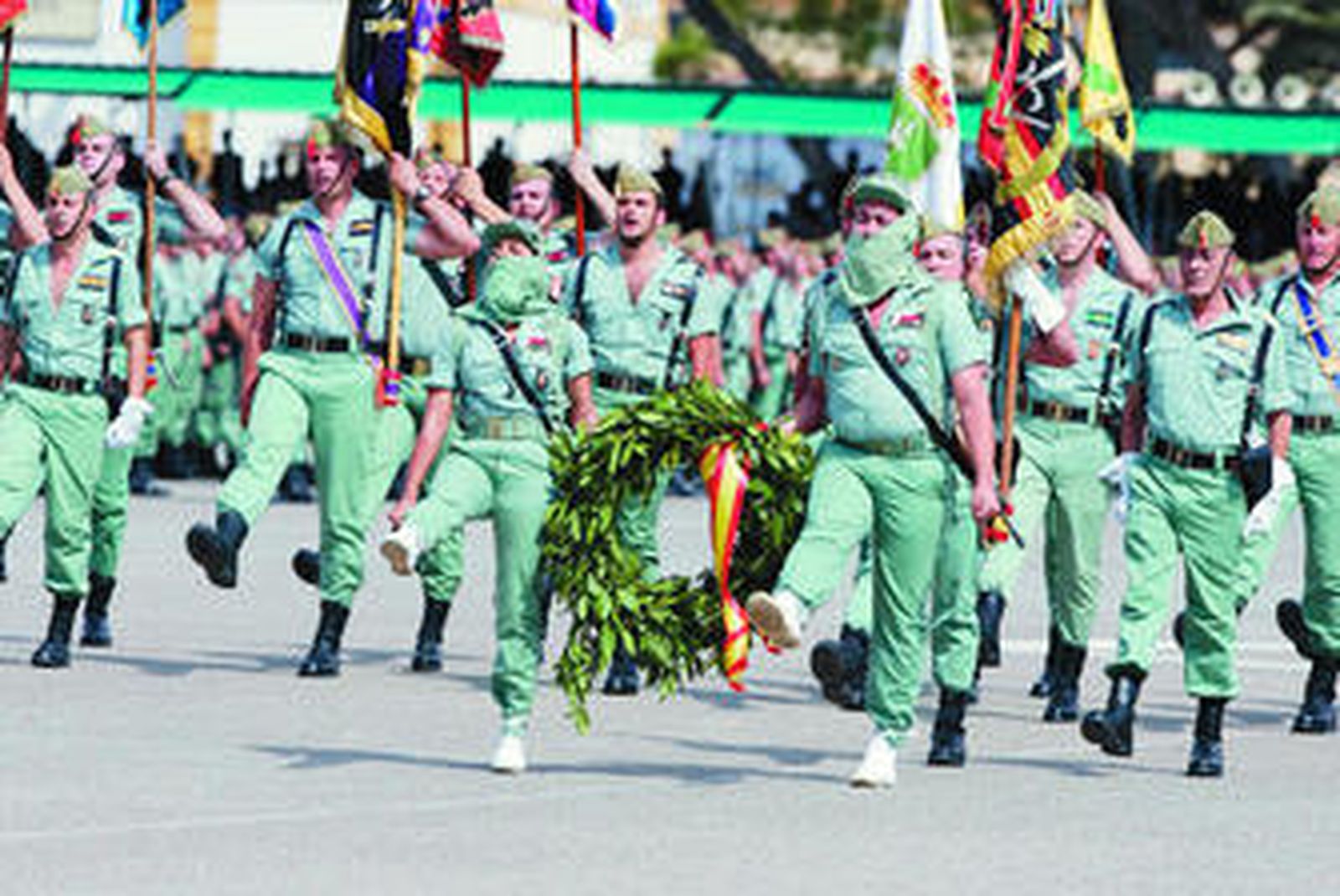 Momento del homenaje a los muertos en que los guiones y banderines se dirigen hacia el monumento a los caídos.