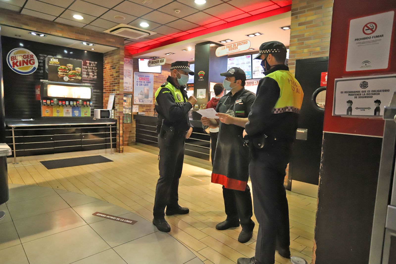 Los policías entregan un documento con las medidas en Burguer King.