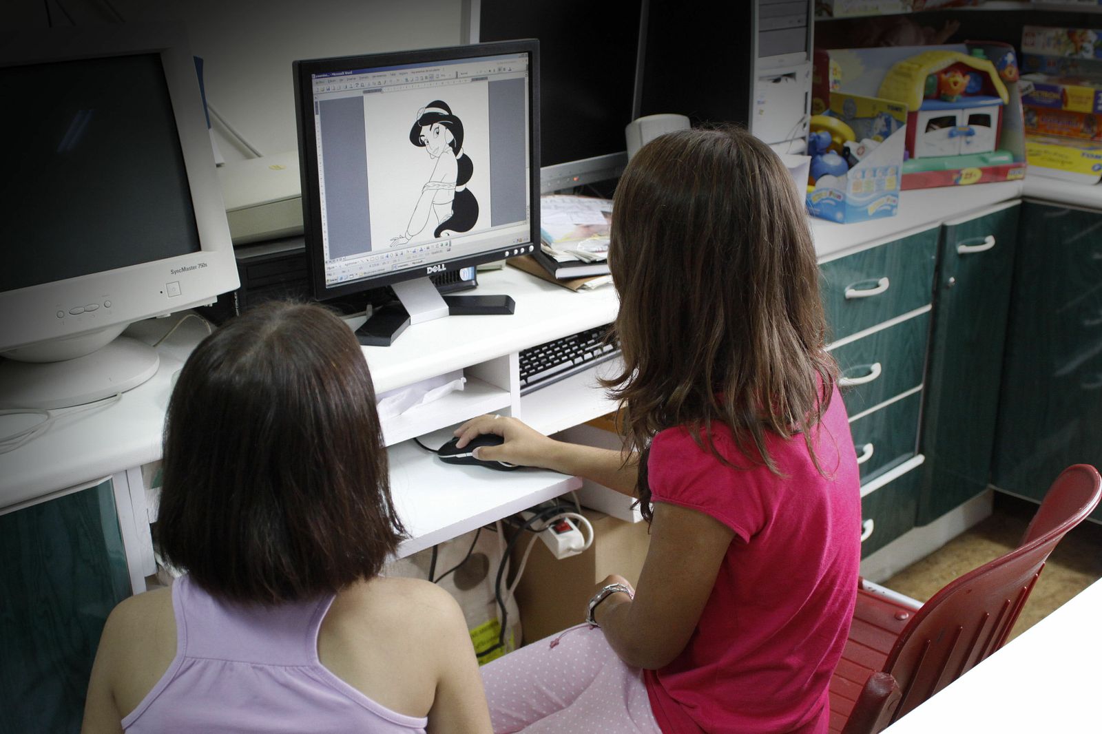 Dos menores juegan con una aplicación infantil en un ordenador.