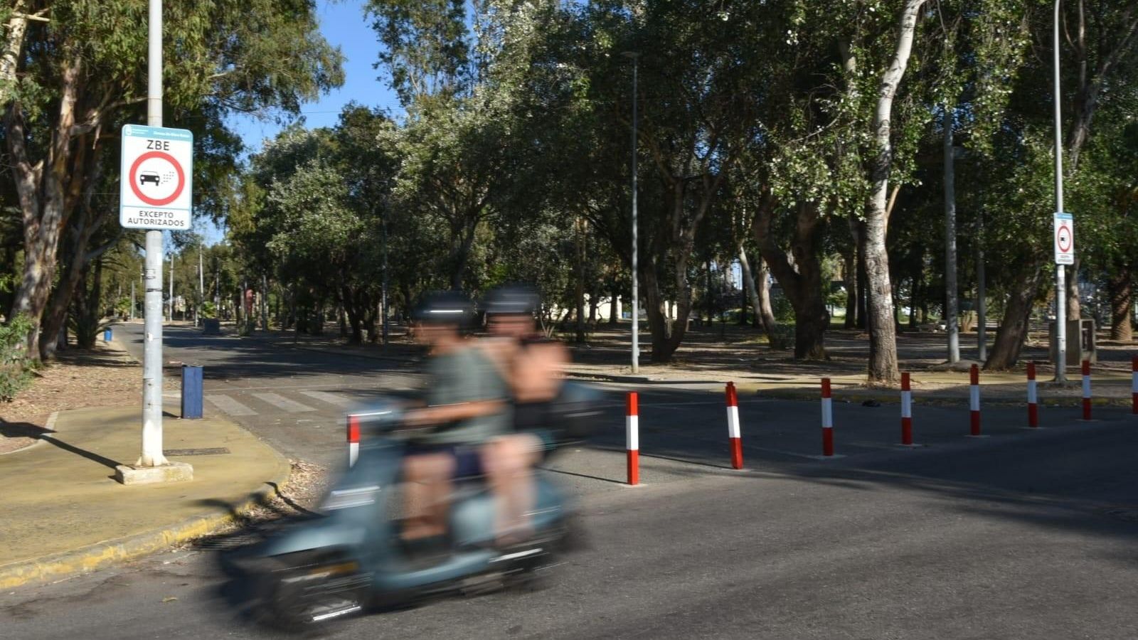 Una moto circula junto al inicio de la Zona de Bajas Emisiones del Parque Princesa Sofía de La Línea.