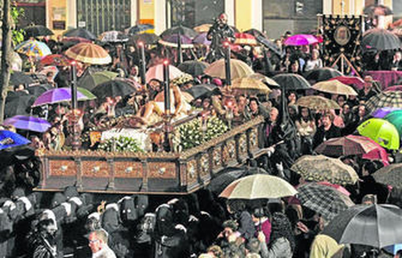 El paso del Cristo de la Caridad por la Plaza Alta en un instante de lluvia más intenso, el Viernes Santo.