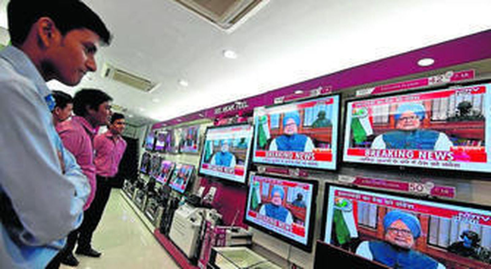 Ciudadanos indios observan en la televisión al Primer Ministro. / AFP