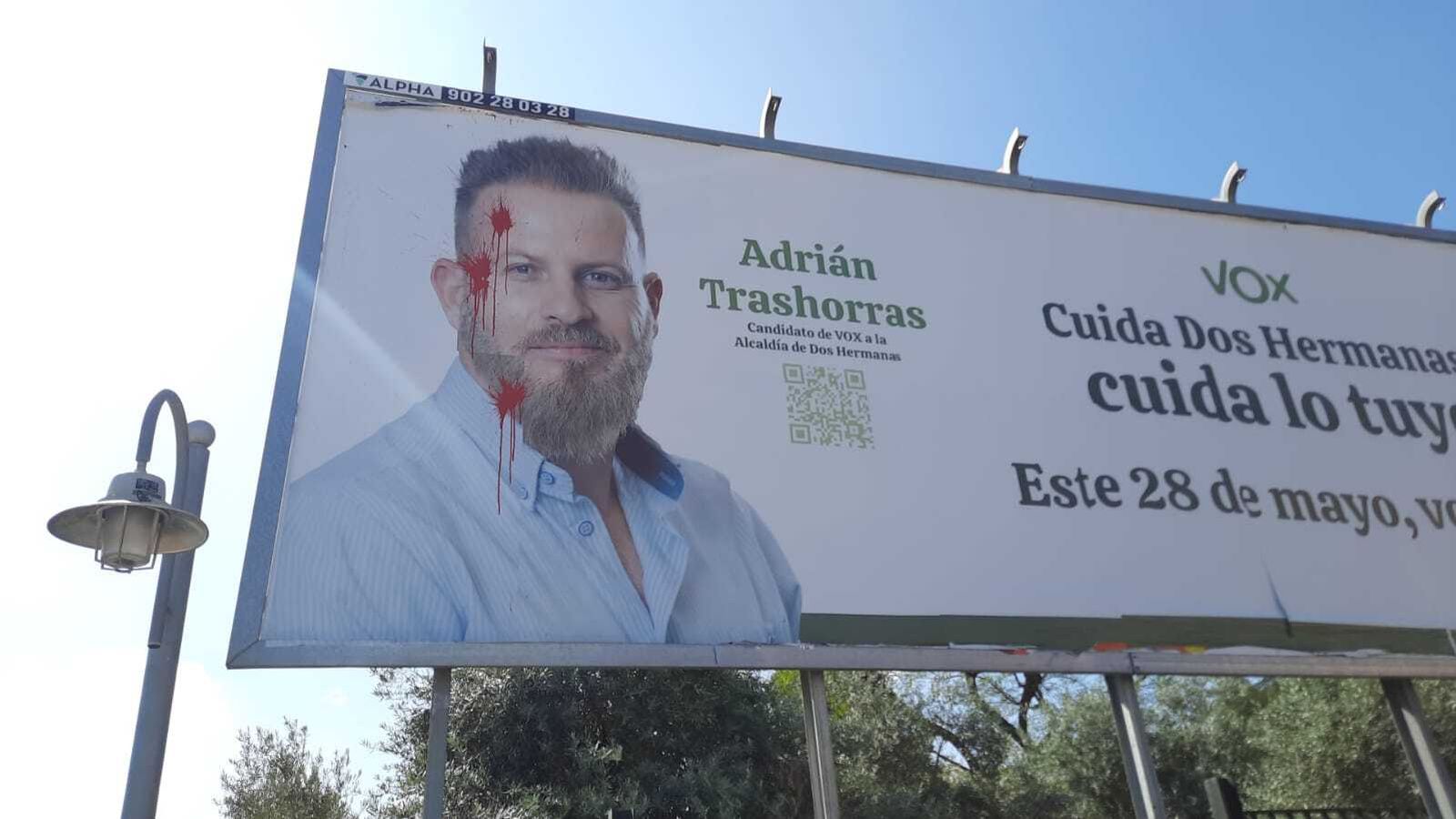 Aparecen pintas que simulan "tres impactos de bala" en una valla electoral del candidato de Vox en Dos Hermanas