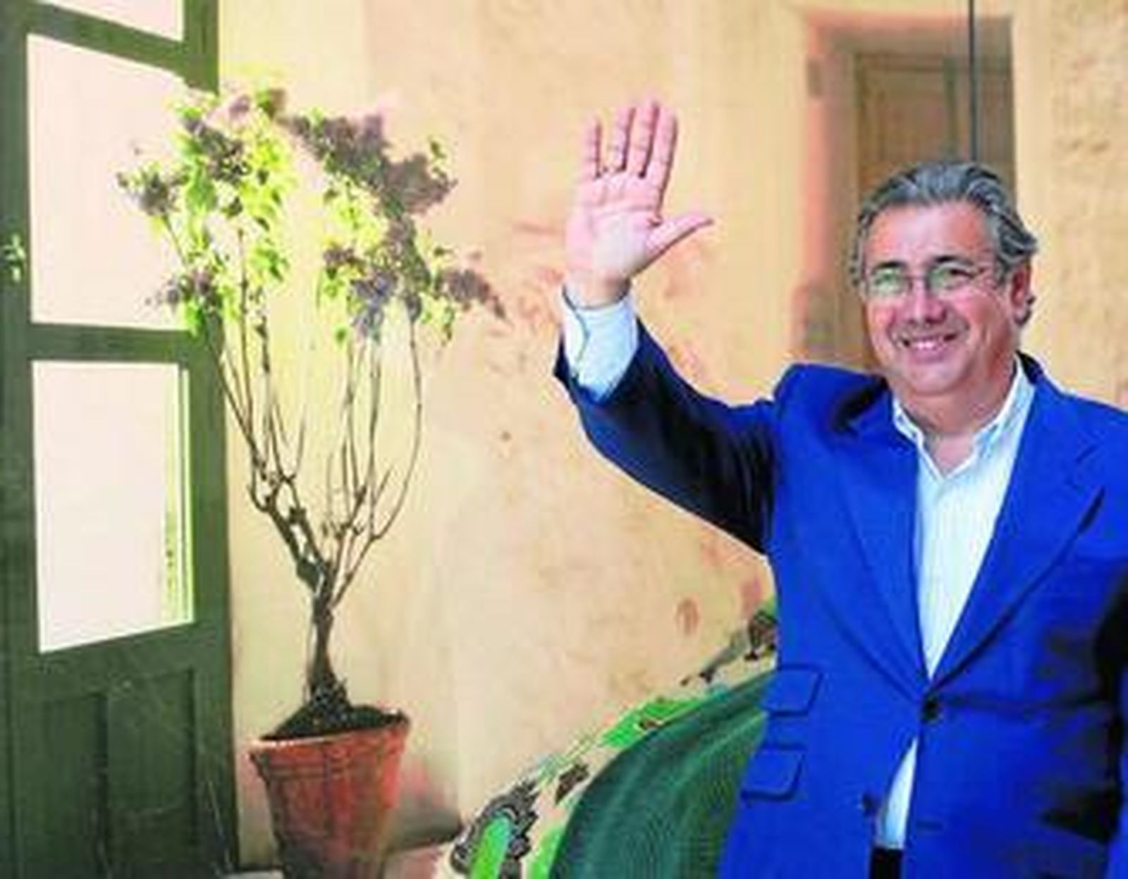 Juan Ignacio Zoido saluda mientras pasa por delante de un escaparate en el centro de Sevilla.