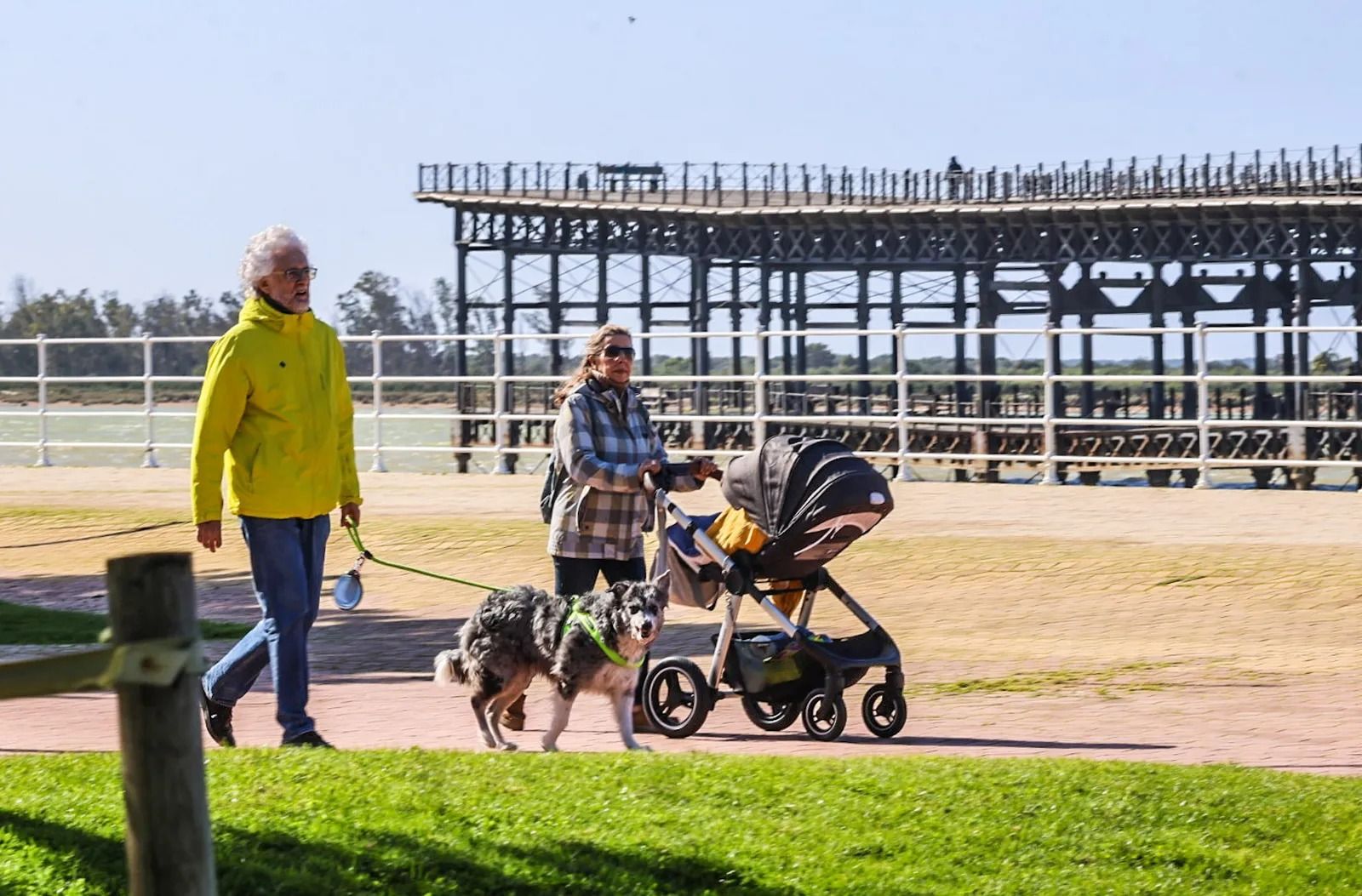Varias personas pasean por Huelva durante un día soleado.