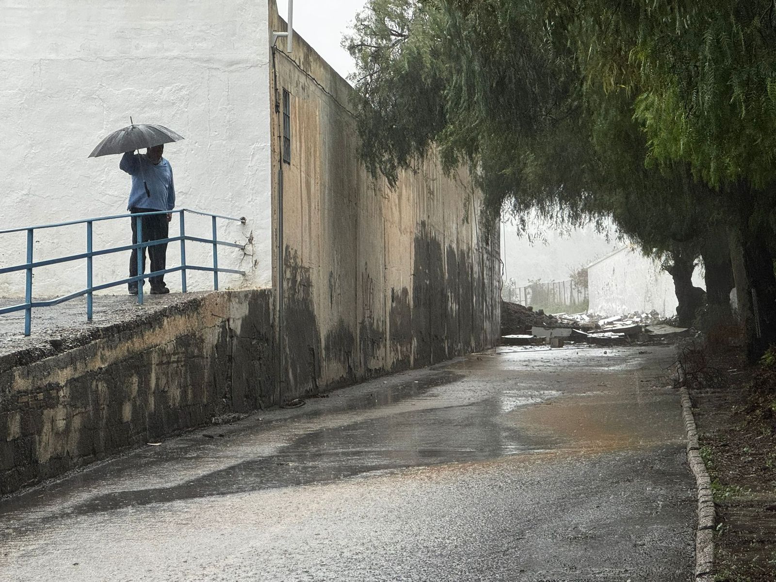 Una persona mira parte del muro derrumbado en el Escribano Castilla de Motril