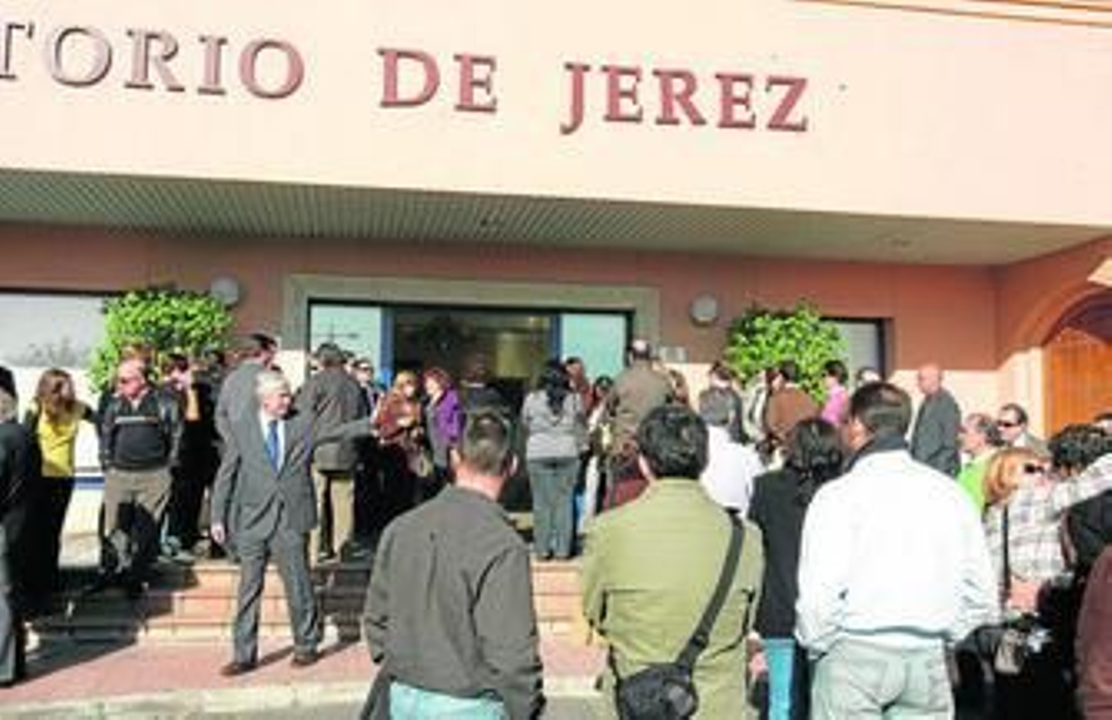 Familiares y amigos esperan la salida de un ataúd en el exterior del Tanatorio de Jerez.