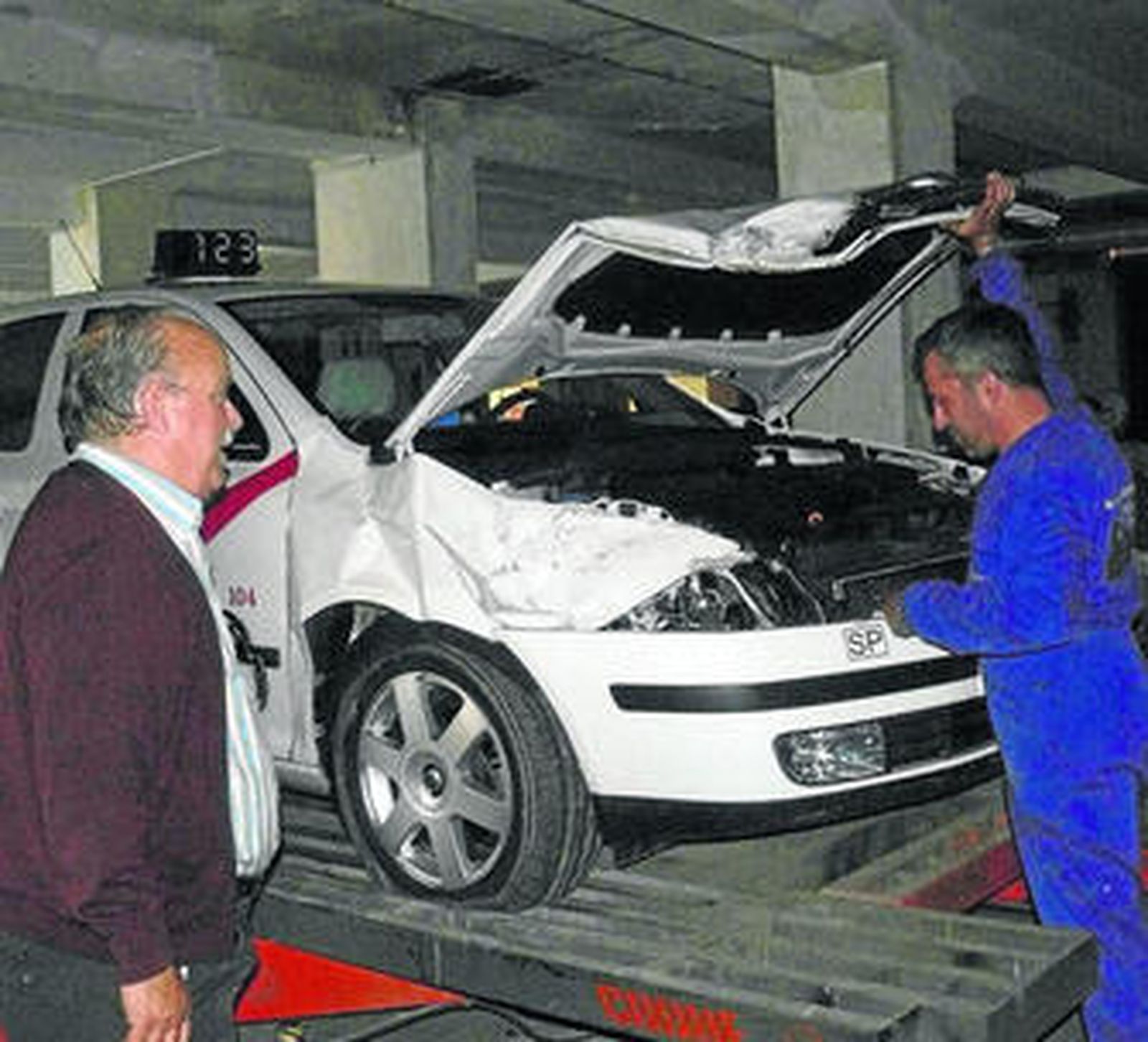 El dueño del taxi dañado por la roca se lamentaba en el taller de lo ocurrido y se recuperaba del susto.
