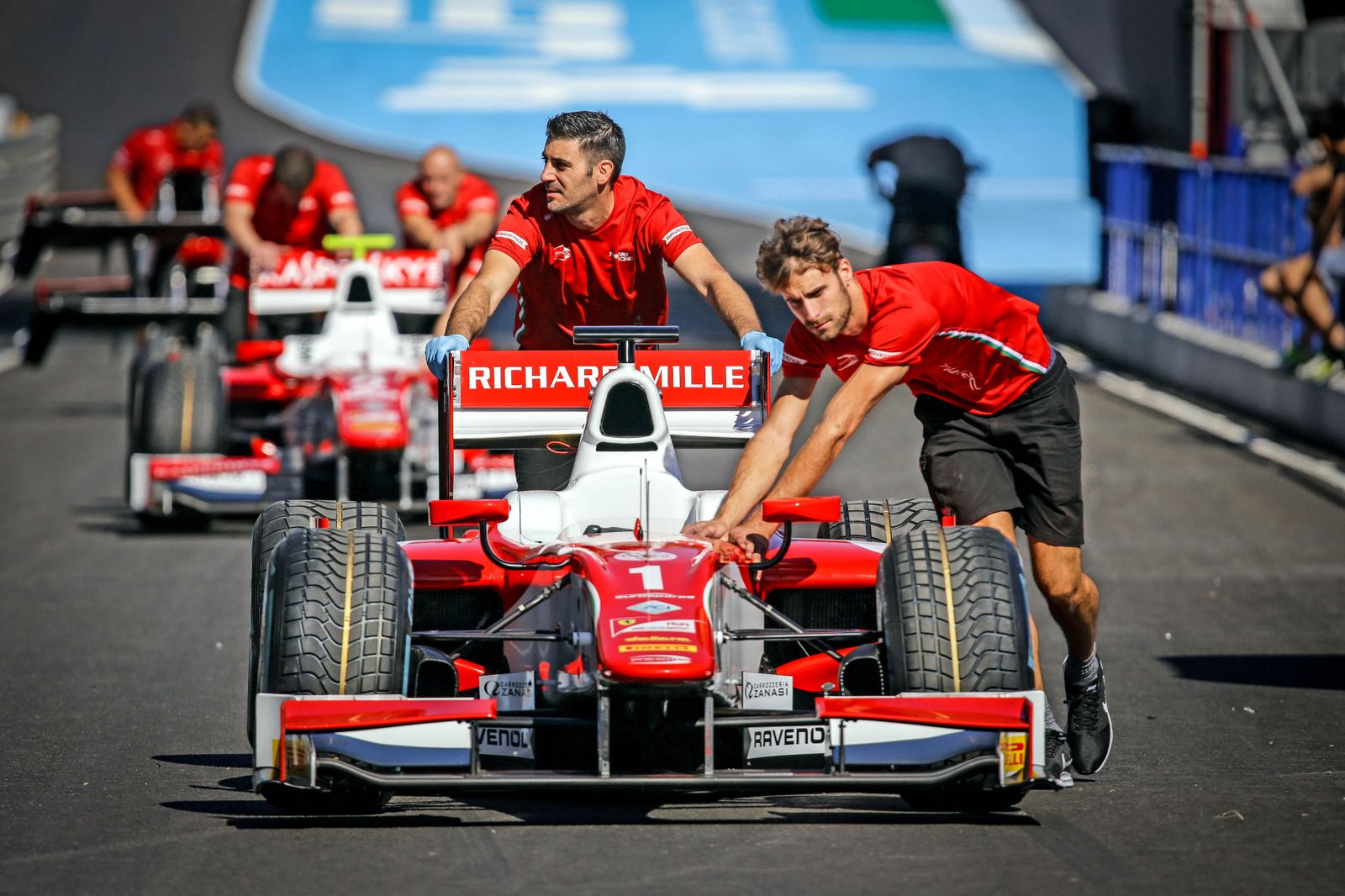 Un par de mecánicos del equipo Prema Racing empujan el Fórmula 2 de Charles Leclerc, líder del Mundial.