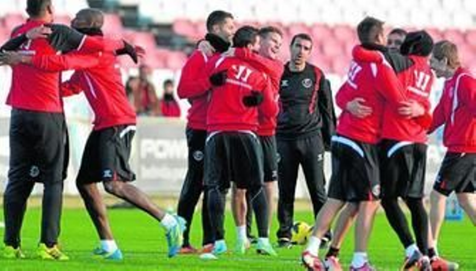 Los jugadores del Sevilla se divierten durante uno de los ejercicios del entrenamiento vespertino de ayer en la ciudad deportiva.