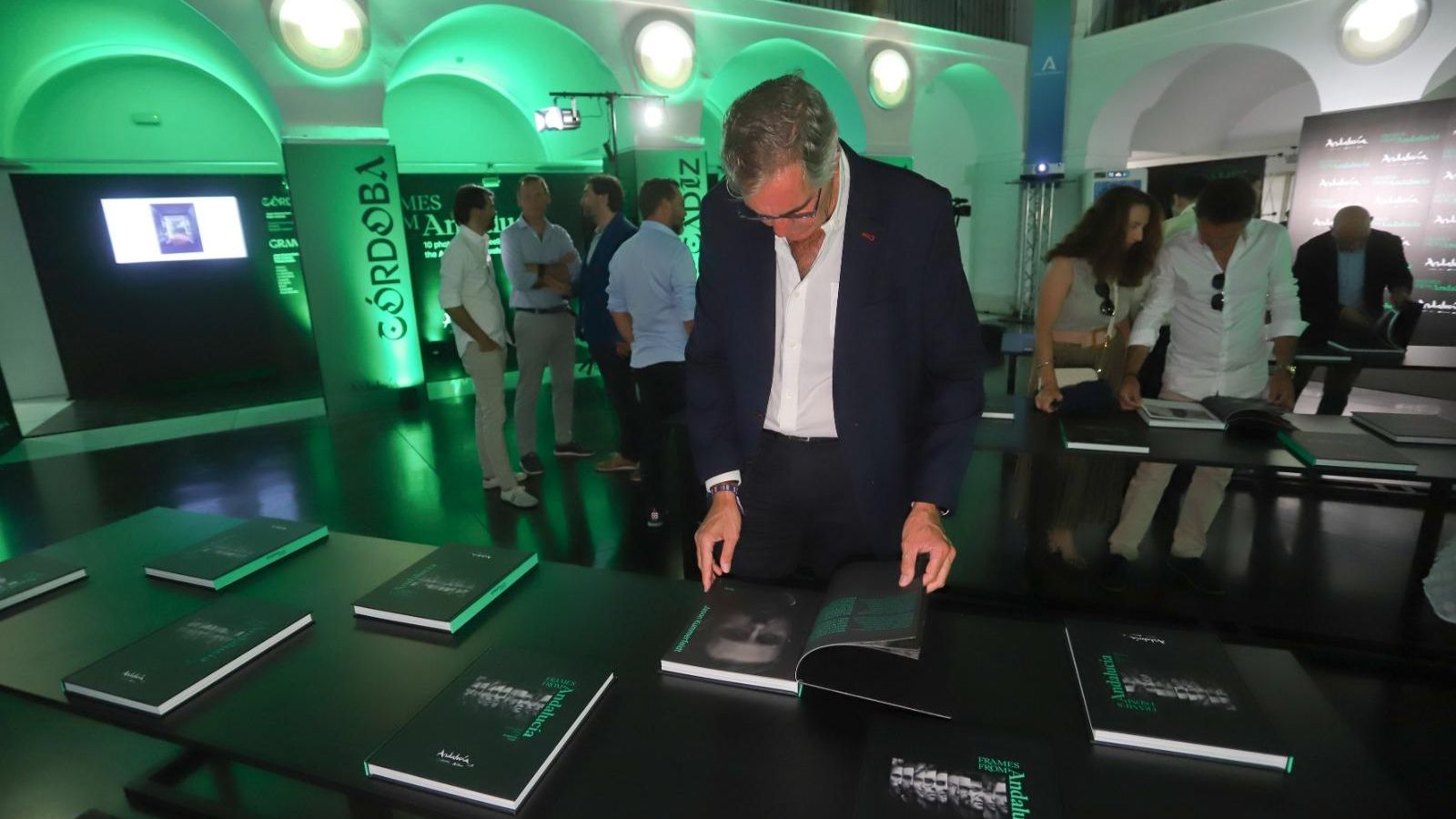 Un invitado hojea el libro que se ha impreso con una selección de fotografías.