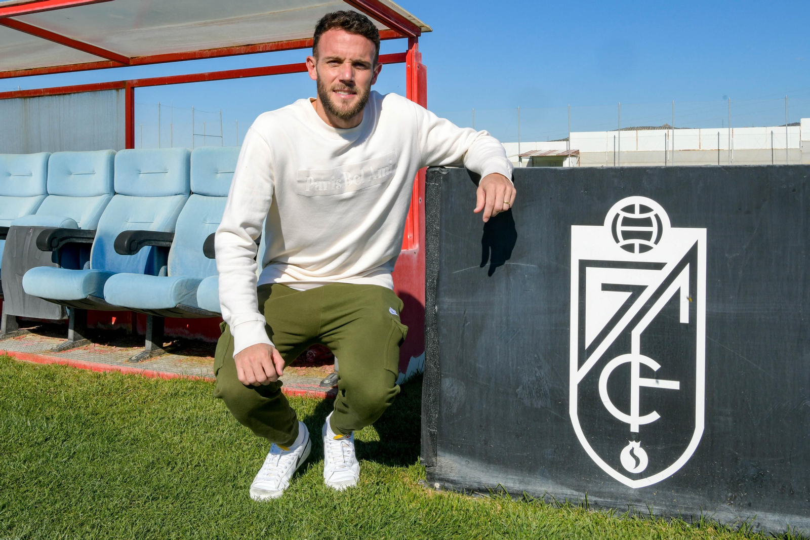 Quini posa junto al escudo del Granada en la ciudad deportiva de la entidad