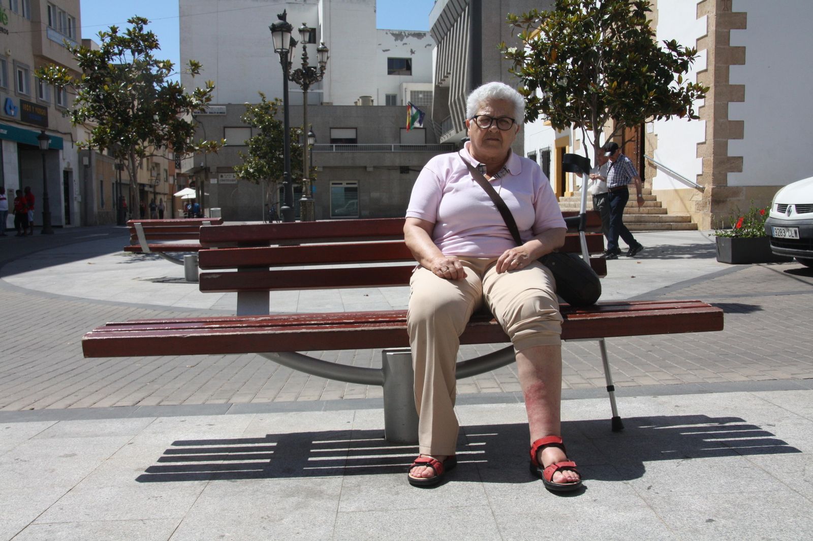 Amelia Requena, en un banco de la Plaza de la Constitución de Roquetas de Mar, muestra la pierna manifiestamente inflamada.