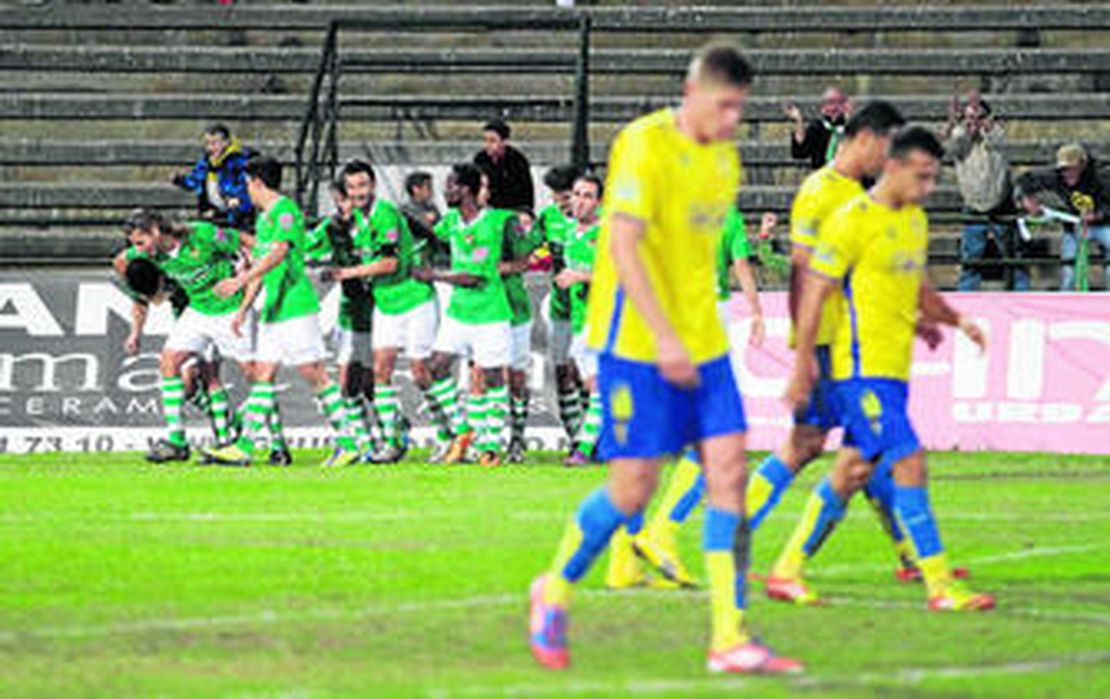 Los jugadores del Cádiz (d), desolados mientras los futbolistas del Cacereño celebran un gol.