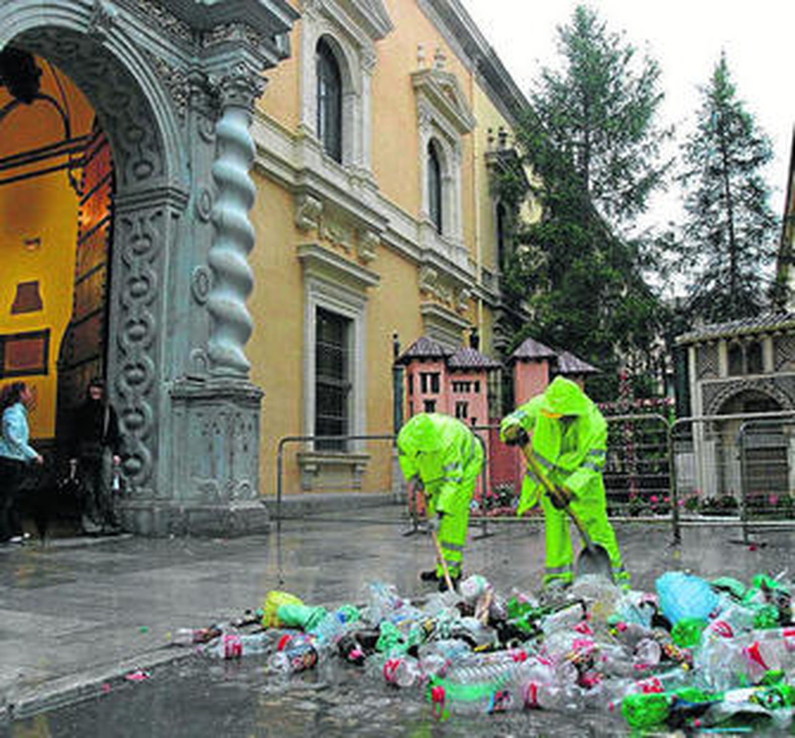 Dos trabajadores retiran los restos de una de las fiestas de los alumnos de Derecho.