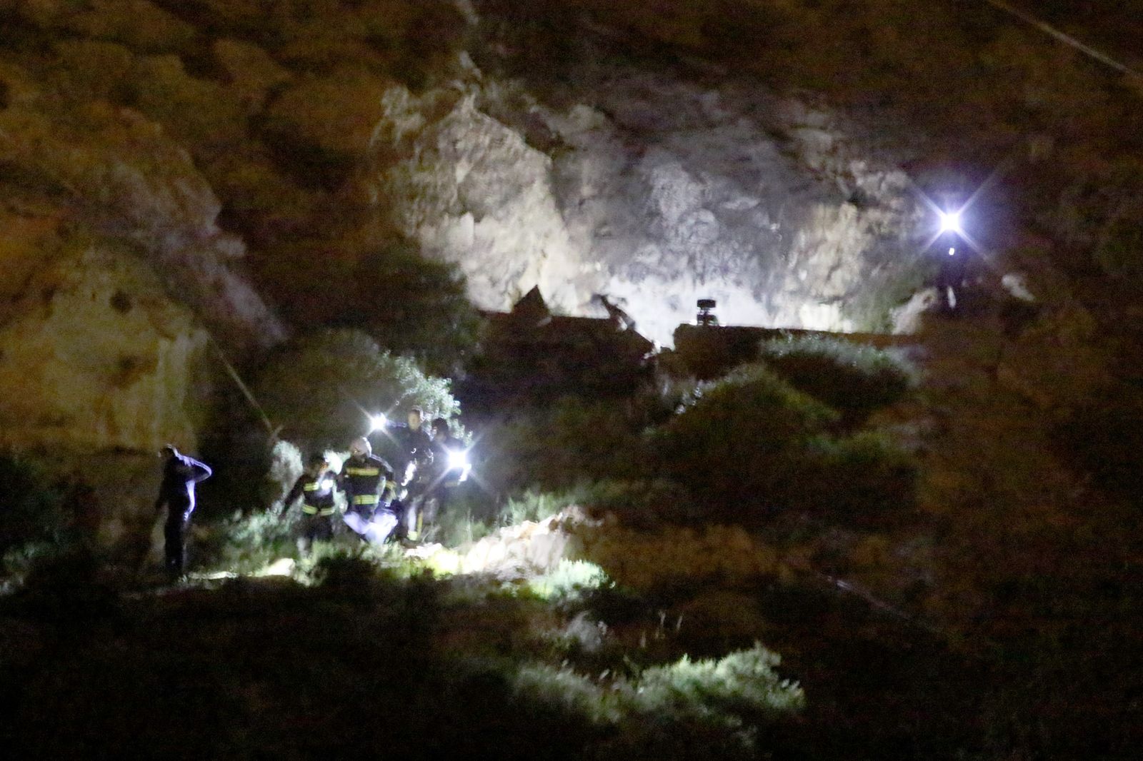 Bomberos y policías sacan los cuerpos de los jóvenes de la casa cueva de La Molineta.