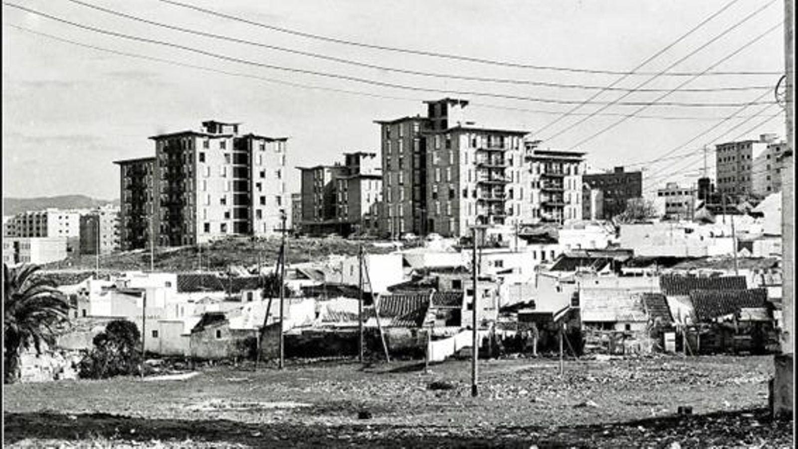 El contraste entre dos mundos: en primer plano, las subdesarrolladas y caóticas edificaciones de la barriada “Hotel Garrido”, en su parte baja y hoy desaparecida, Al fondo, la urbanización  “Carteya”, fruto de los planes de desarrollo y que hoy disfruta de los mejores jardines urbanos de la ciudad.