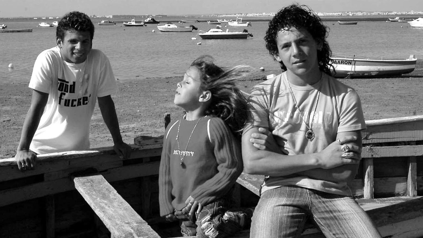 Isra Gómez con sus hermanos Cheíto (detrás de la barca) y Cecilio, en 2006 en la playa de La Casería donde rodaron 'La leyenda del tiempo'.