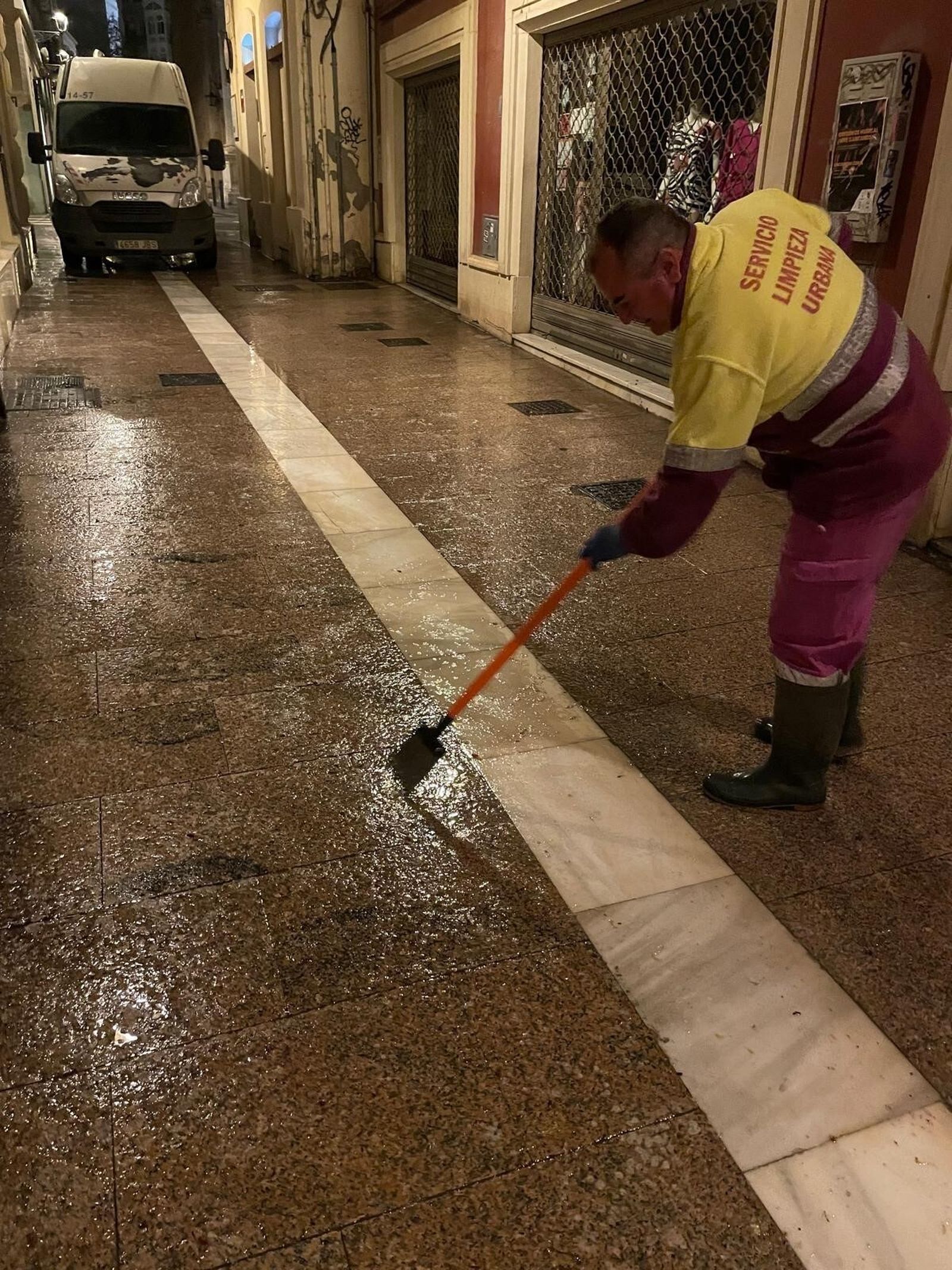 Un operario municipal limpia la calle Las Tiendas de cera.