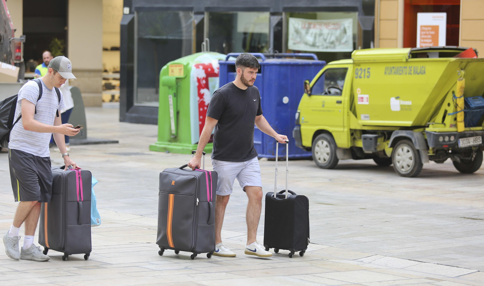 Dos turistas van con sus maletas a una vivienda turística en el centro de Málaga
