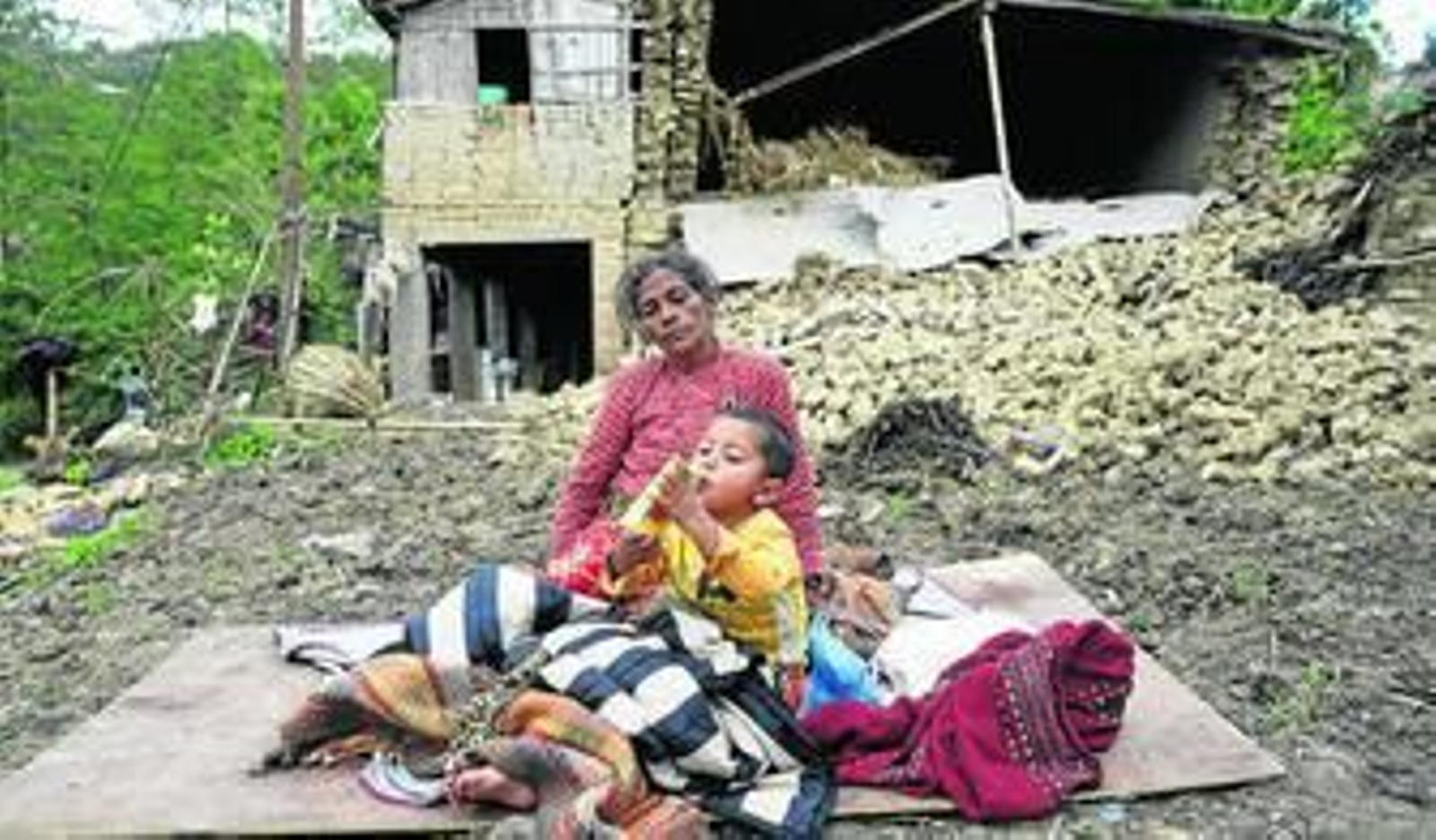 Una mujer y su hijo, ayer en los aledaños de su casa destruida en la aldea de Kumalpur, a las afueras de Katmandú.
