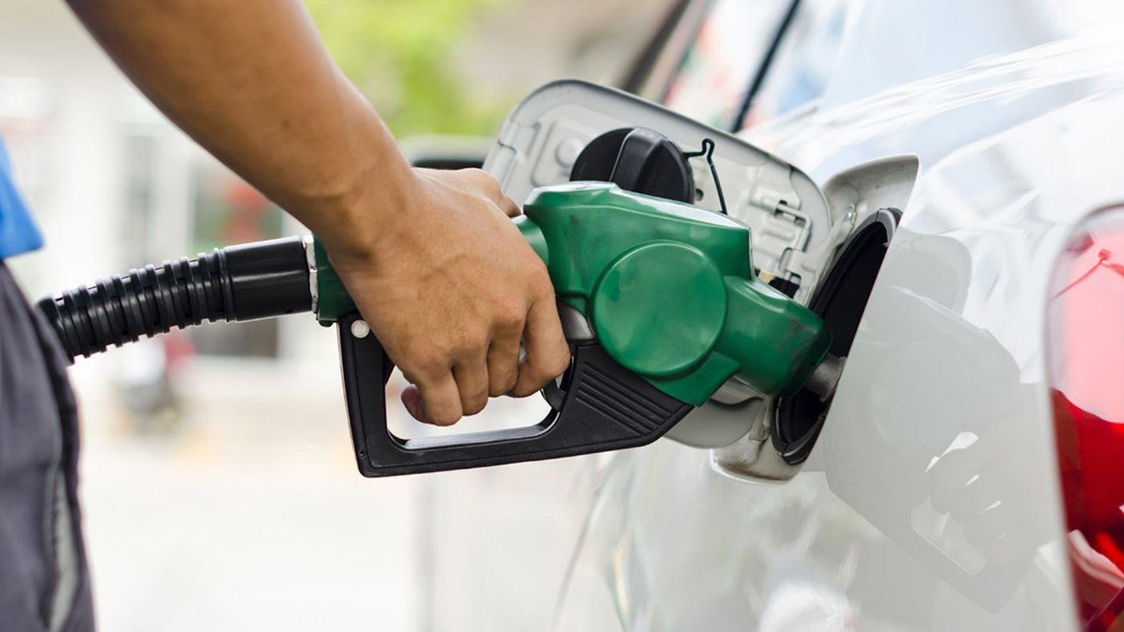 Una persona surte combustible en una gasolinera