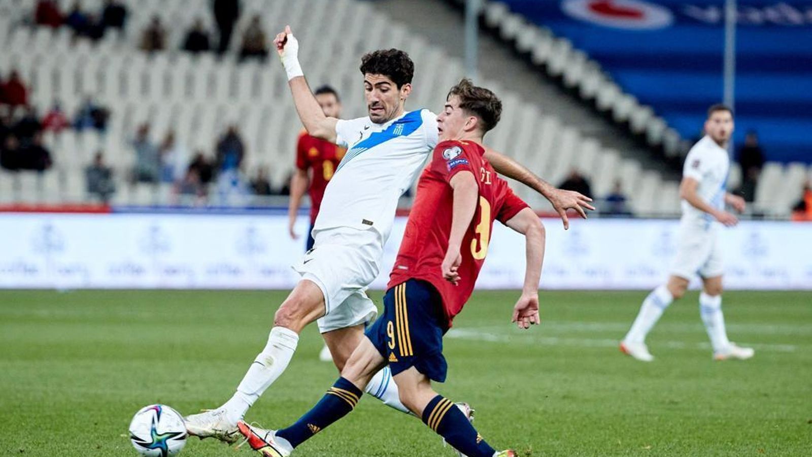 Gavi ejecuta un pase presionado por un jugador griego.