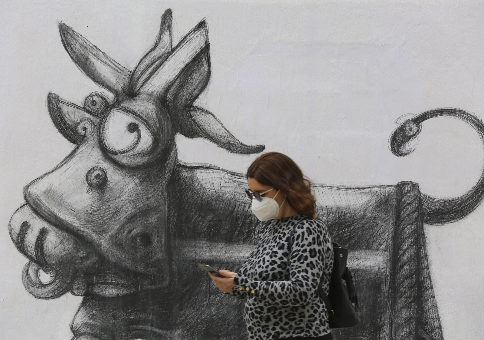 Una mujer con mascarilla pasea por Málaga capital.
