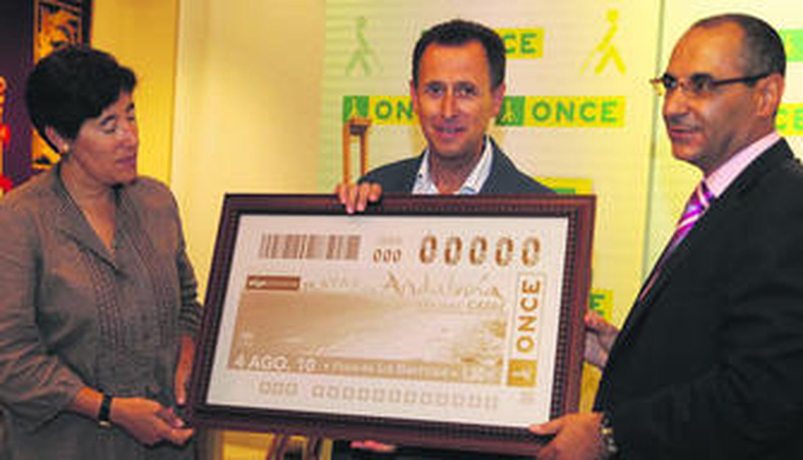 El alcalde con responsable de la organización sostienen la plancha del cupón con la imagen de la playa chiclanera.