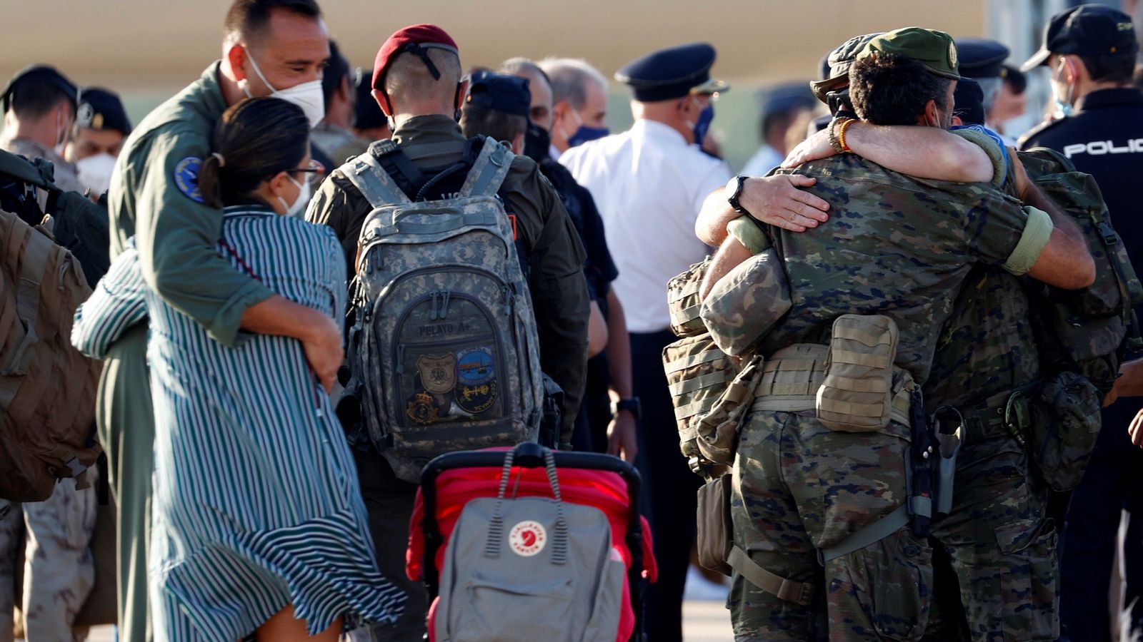 Abrazos entre los refugiados y militares a su llegada a Torrejón.