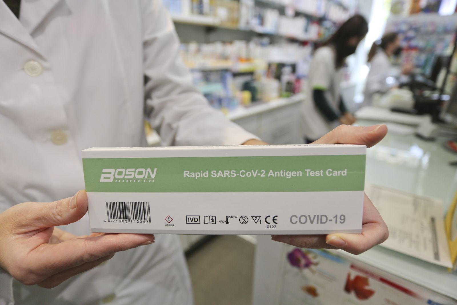 Un farmacéutico muestra un test de antígenos.