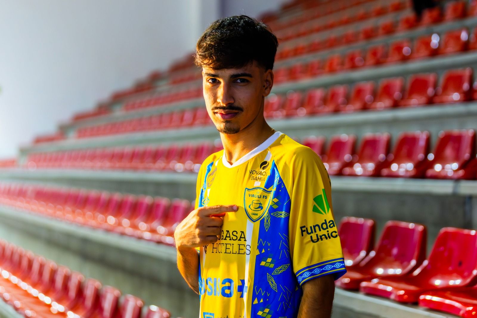 Javi Santana señala al escudo de su nuevo club en un posado en el Ciudad de Cádiz.