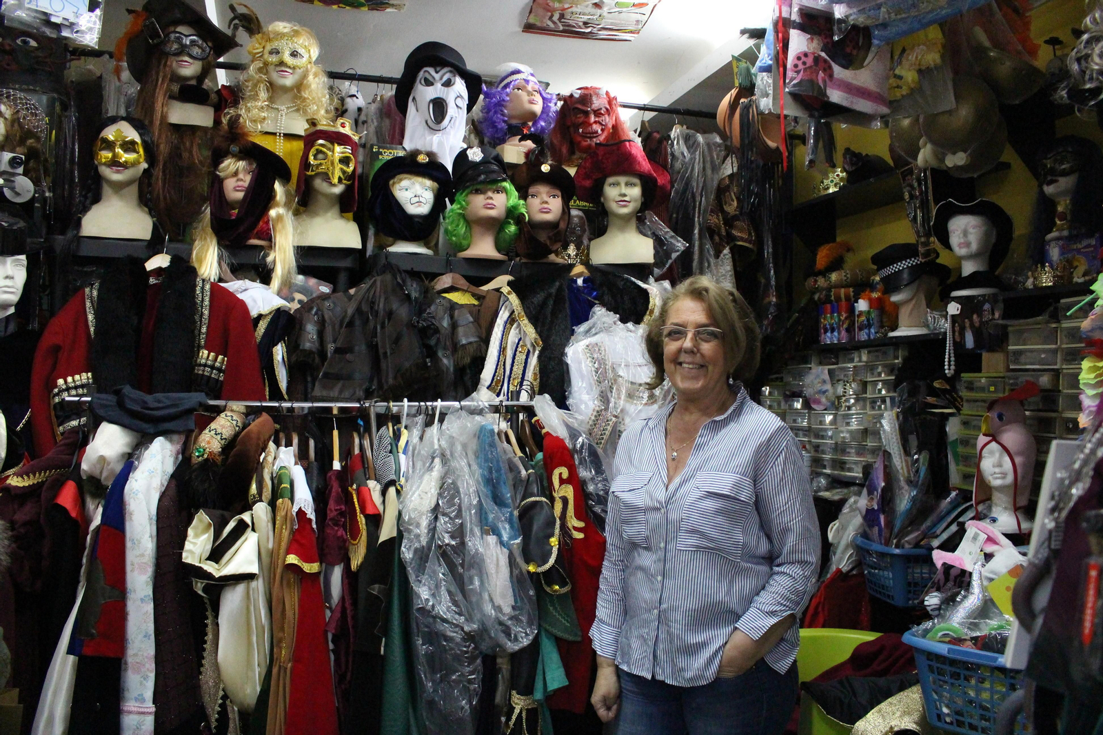 Ana Alvarado, propietaria de la tienda, junto algunos de los disfraces.