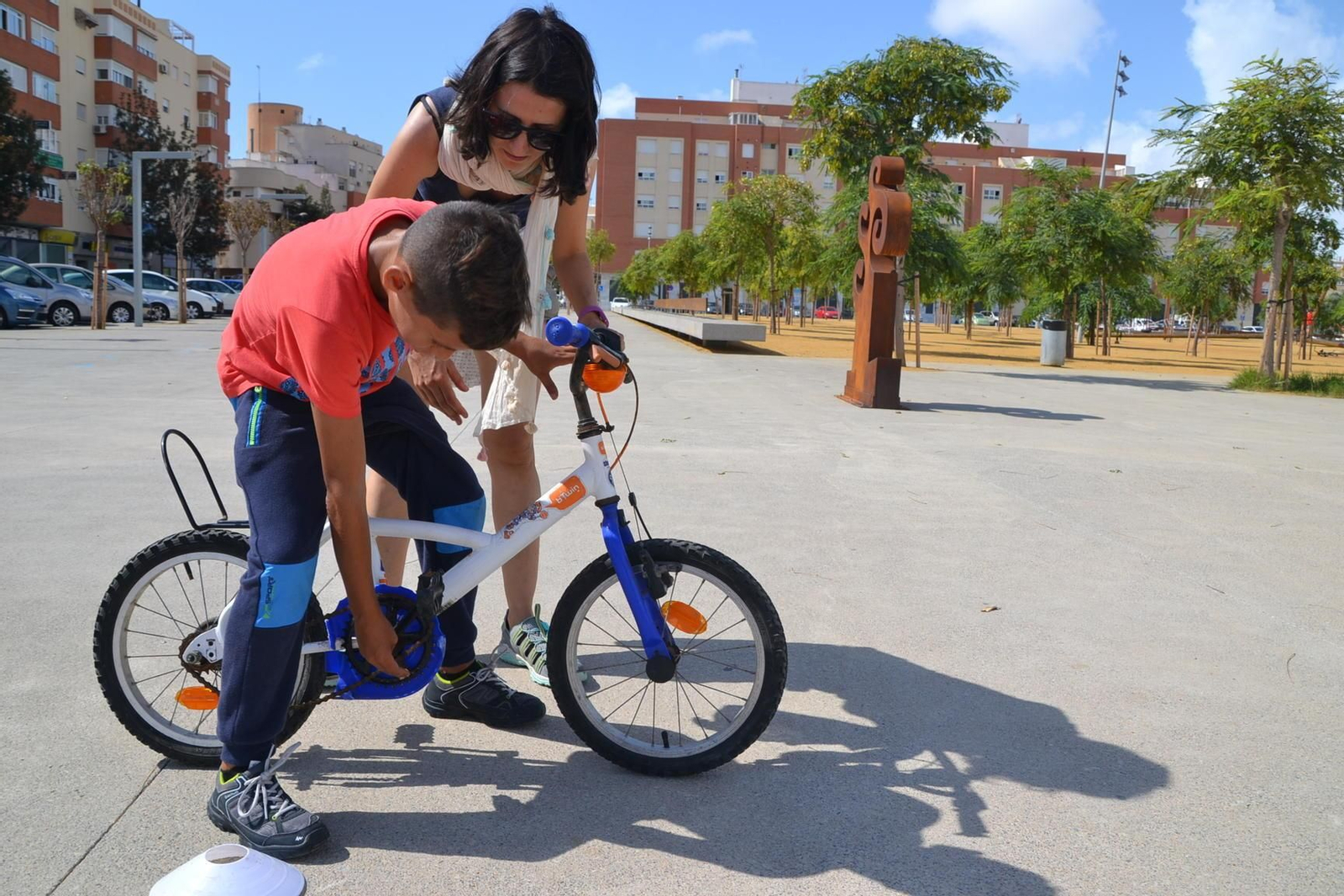 Un niño prepara su bicicleta antes de hacerla rodar.