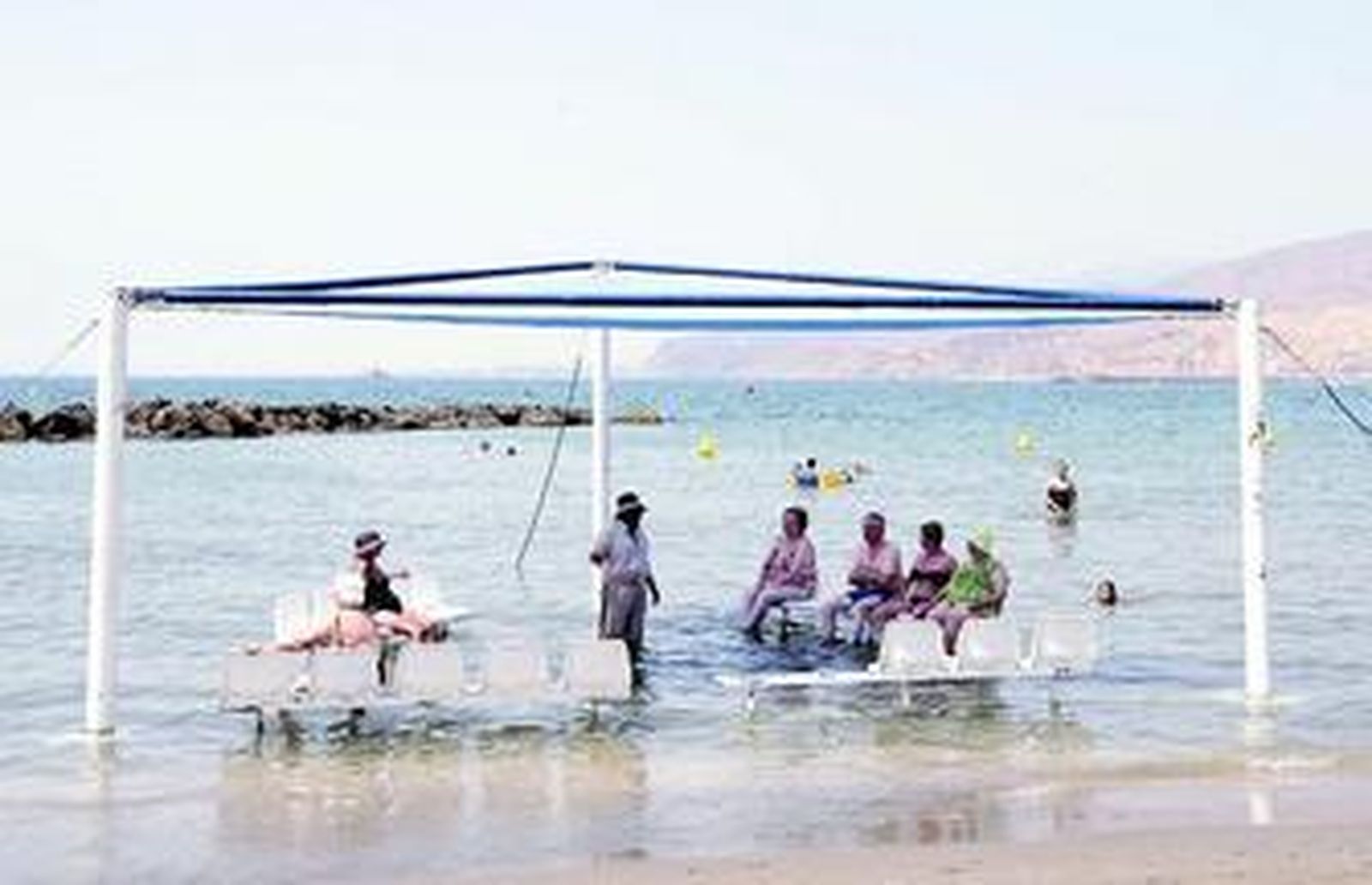 Un grupo de discapacitados disfruta de una jornada de playa.
