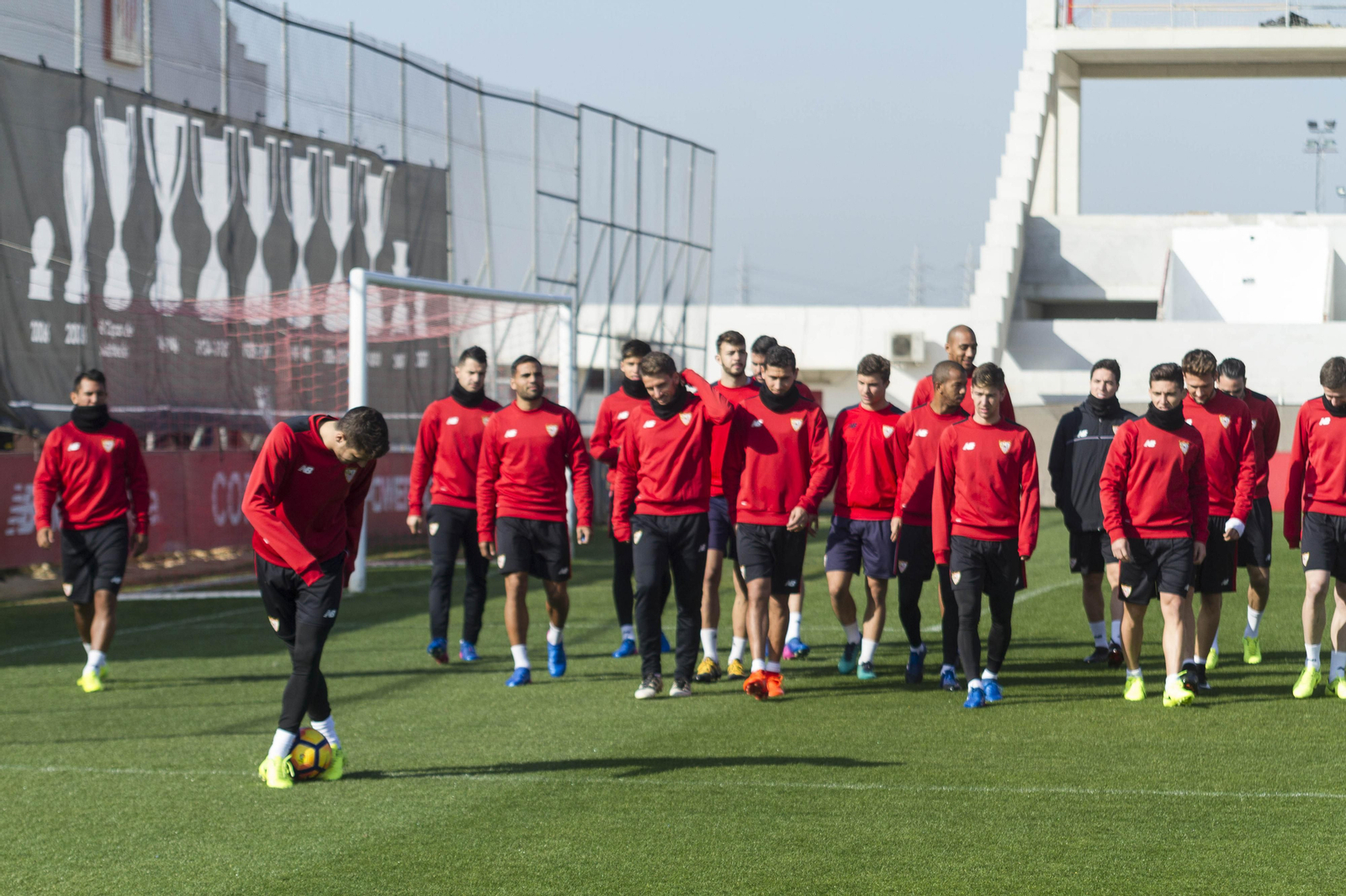 El grupo camina sobre el césped del campo principal de la ciudad deportiva.