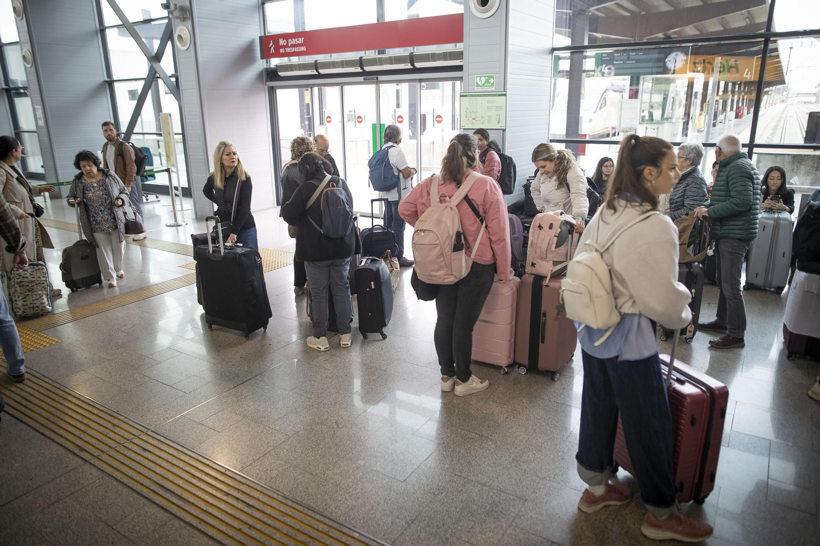 Varios pasajeros esperan la salida de su tren en la estación de Granada