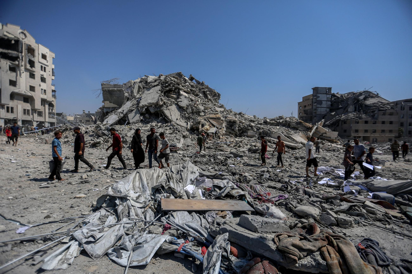 Varios palestinos caminan cerca de un edificio destrozados por las bombas en Ciudad de Gaza.
