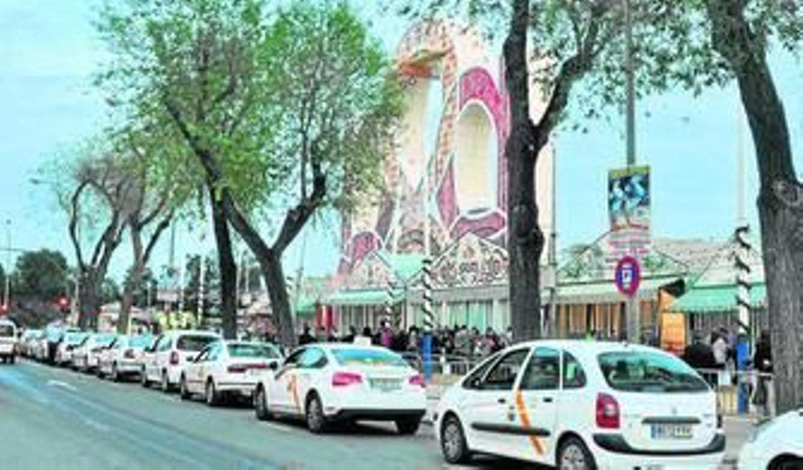 Los taxis dispuestos en fila guardan cola en la parada situada junto a la portada de la Feria.