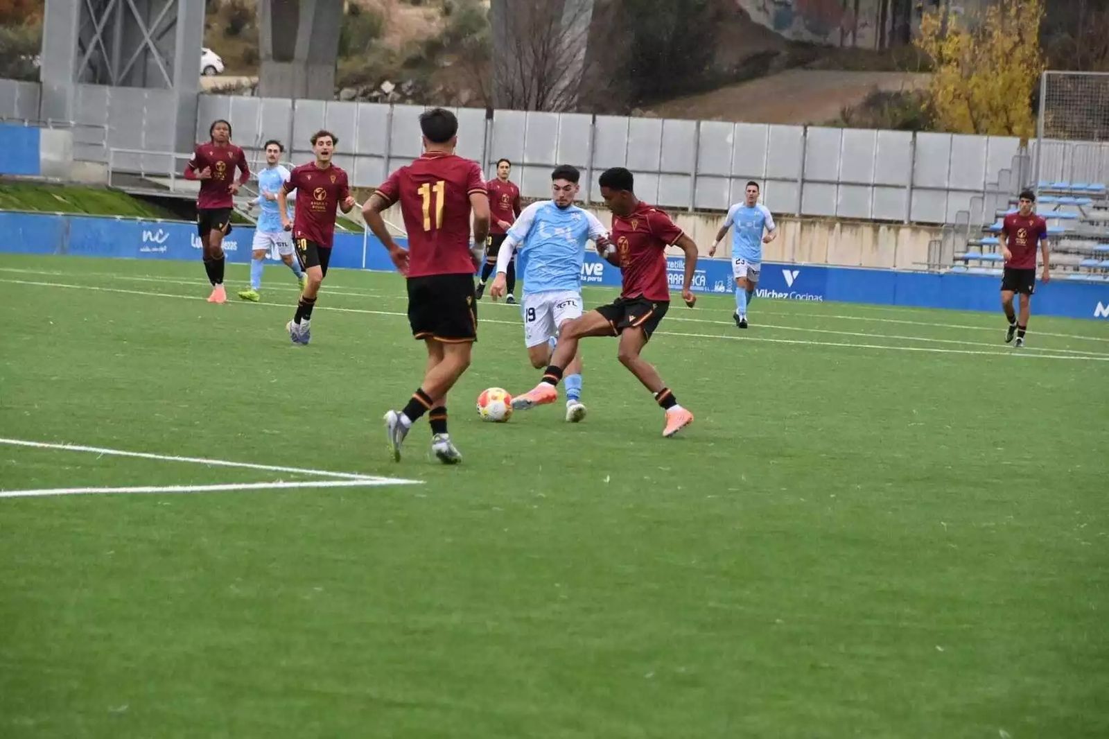 Hugo Fuentes trata de zafarse de dos jugadores del filial.