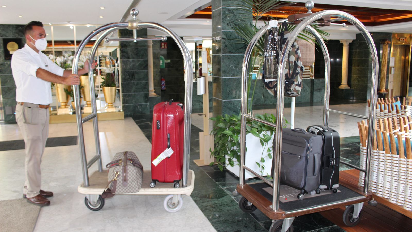 Conserjes transportando el equipaje de unos turistas.