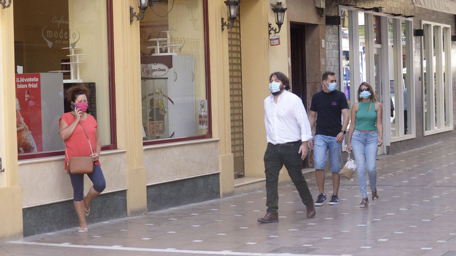 Varias personas, con su mascarilla, por La Línea.