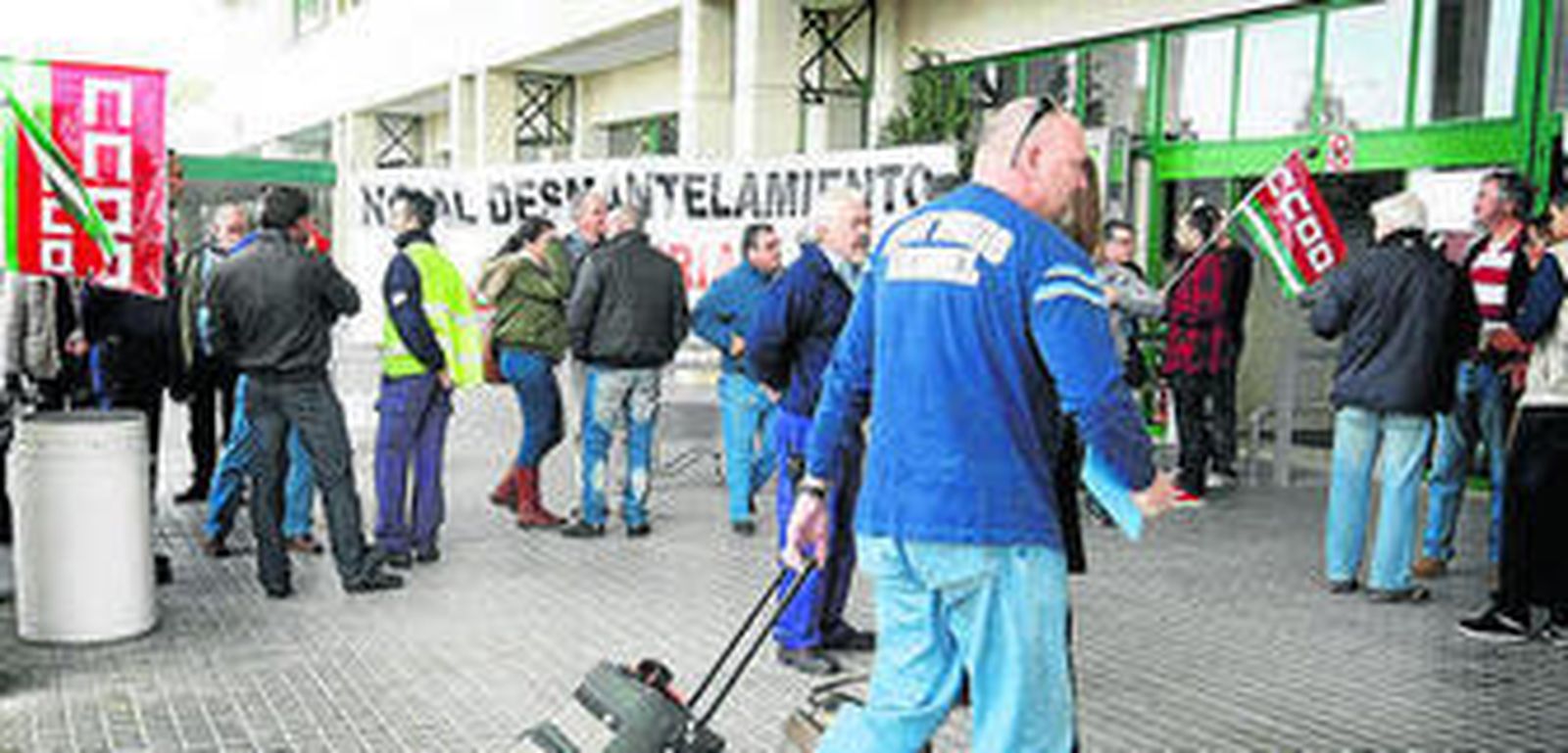 Pasajeros llegando al aeropuerto entre protestas de los trabajadores.