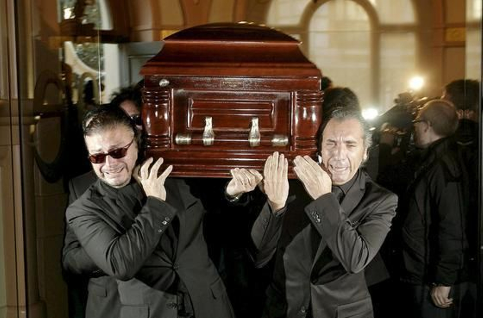 Los portadores del féretro muestran su dolor por la pérdida del cantaor. / EFE