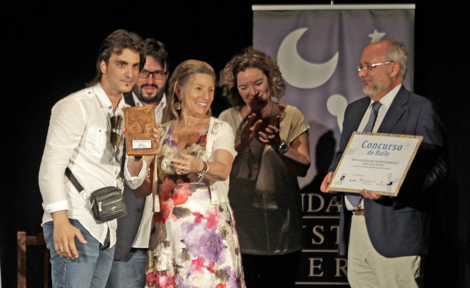 Cristina Heeren y Alberto Marina entregan al sevillano Adrián Domínguez el trofeo y la beca conseguida como ganador.