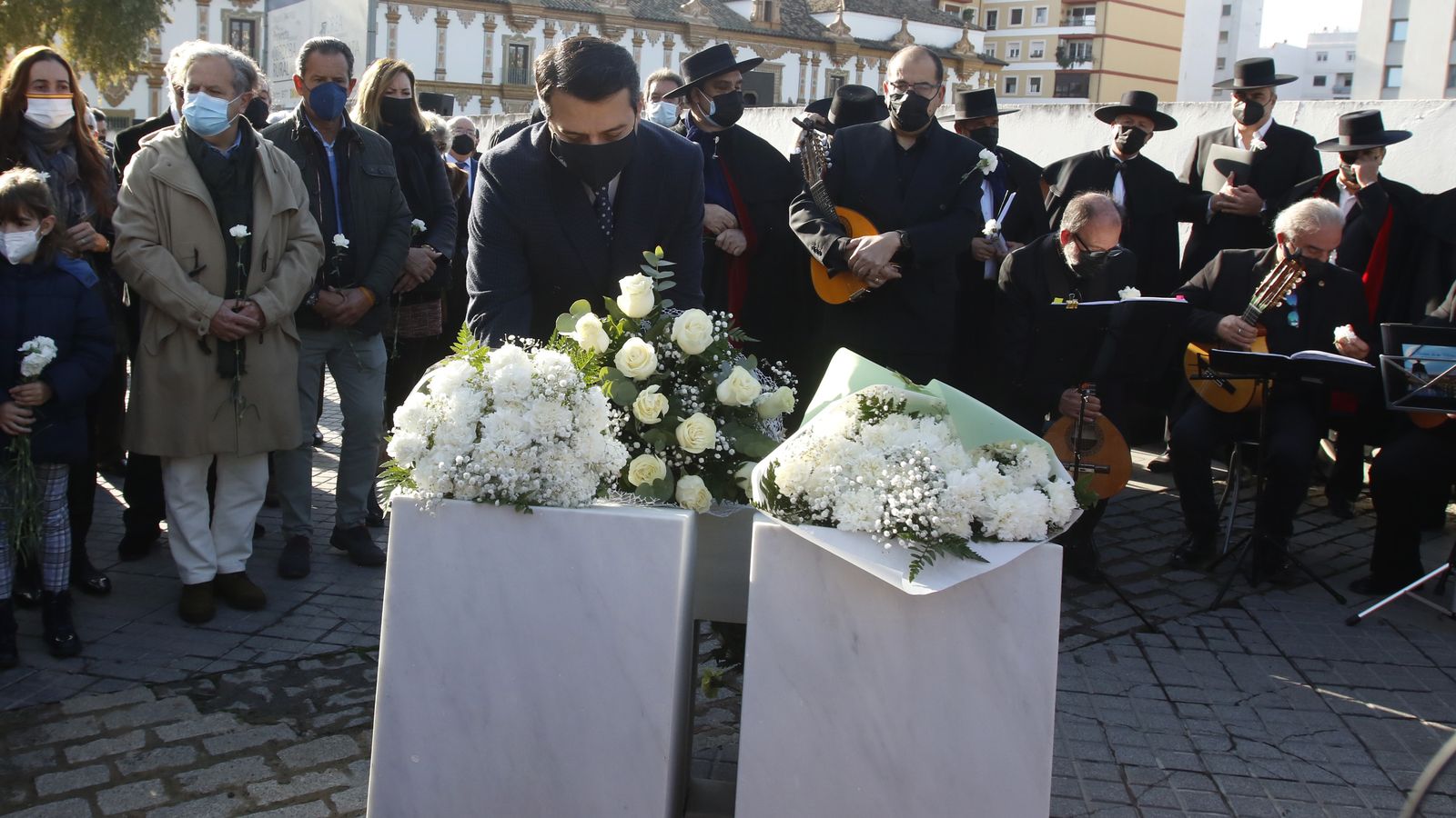 José María Bellido hace entrega de un ramo de claveles blancos en el monolito